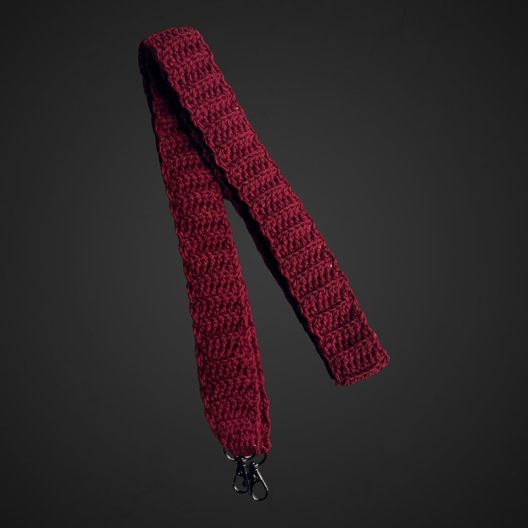 Crocheted phone safety tether in burgundy.  The tether has two lobster clasps attached at either end in gunmetal.. 